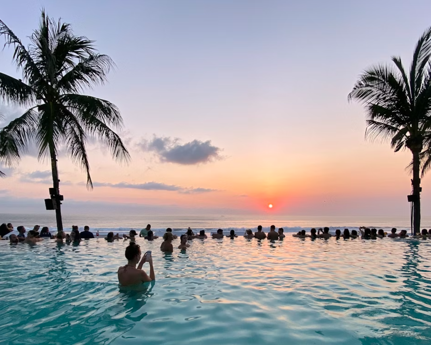Seminyak Beach sunset with beach clubs and surfers