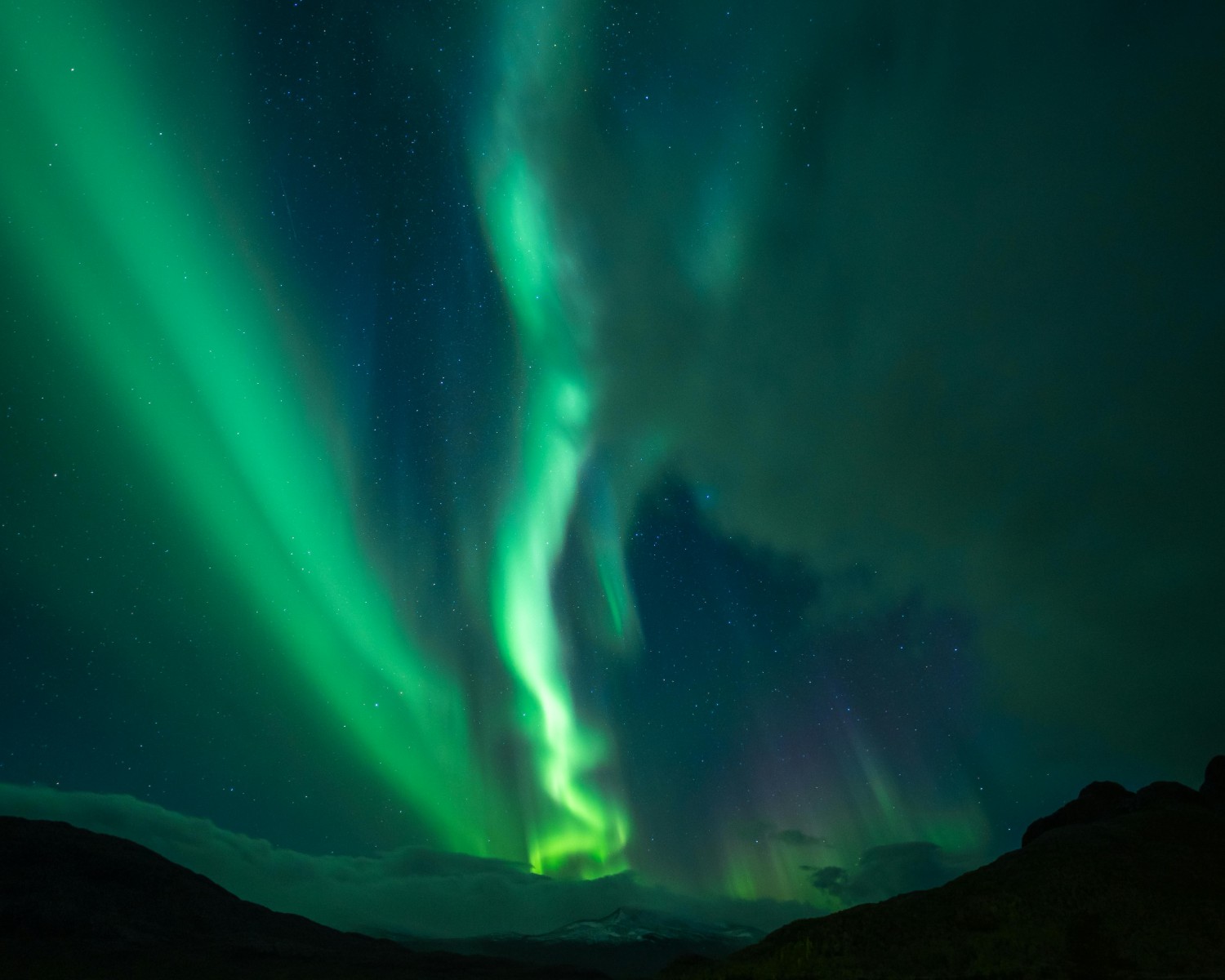 Northern Lights dancing across Arctic sky in emerald green waves